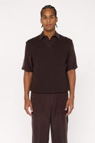 Maroon brown cotton and lyocell knit vest with a relaxed fit, worn over a shirt.